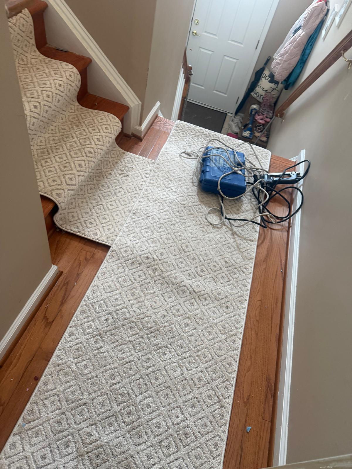 New patterned carpet runner being fitted along a landing and staircase