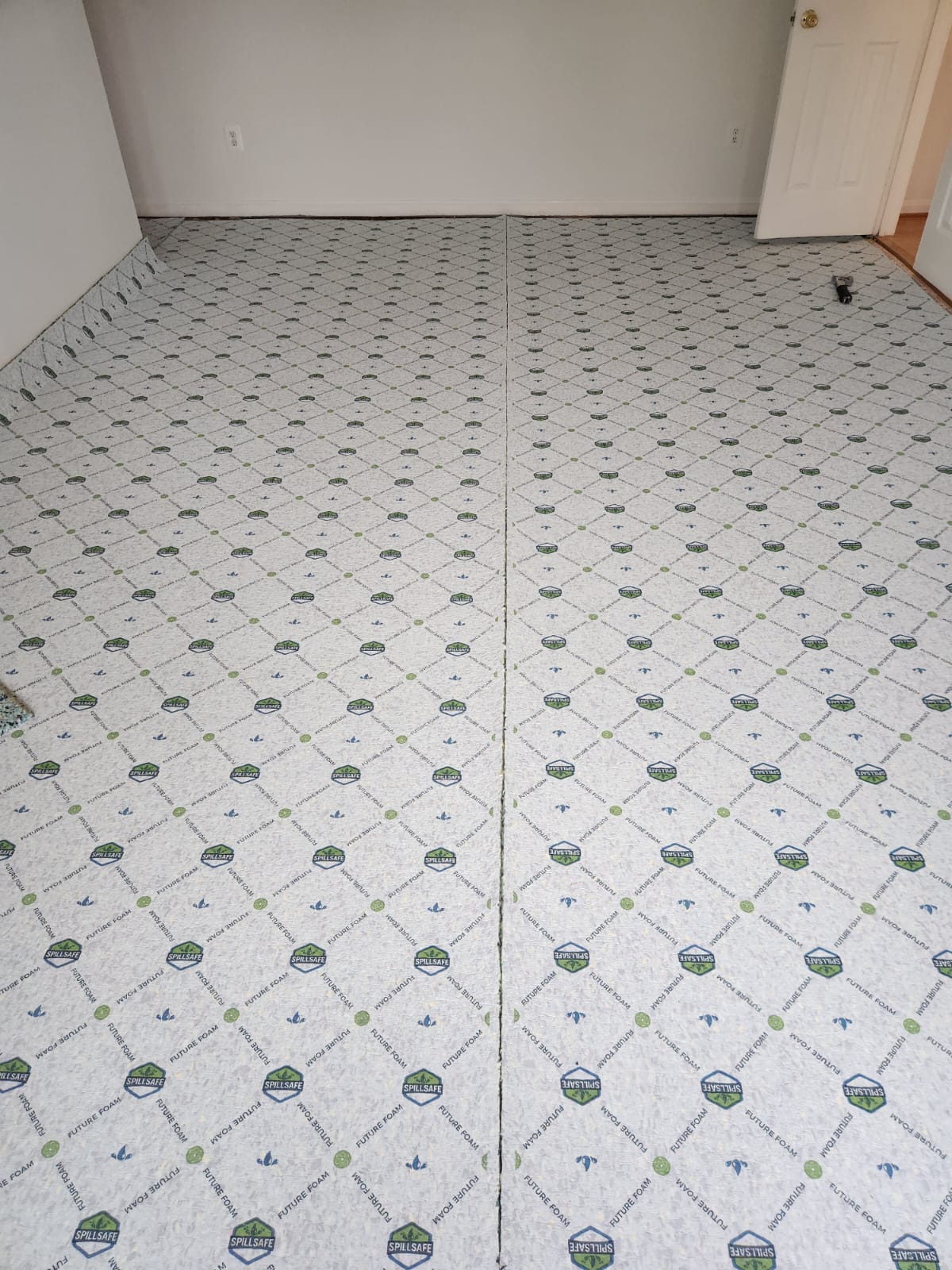 New spill-safe carpet padding laid across a bedroom floor
